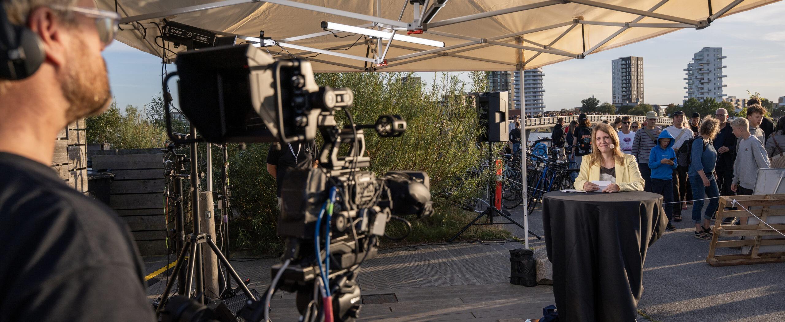 Billede af en TV-fotograf der står bag kameraet til liveproduktionen af SOL26